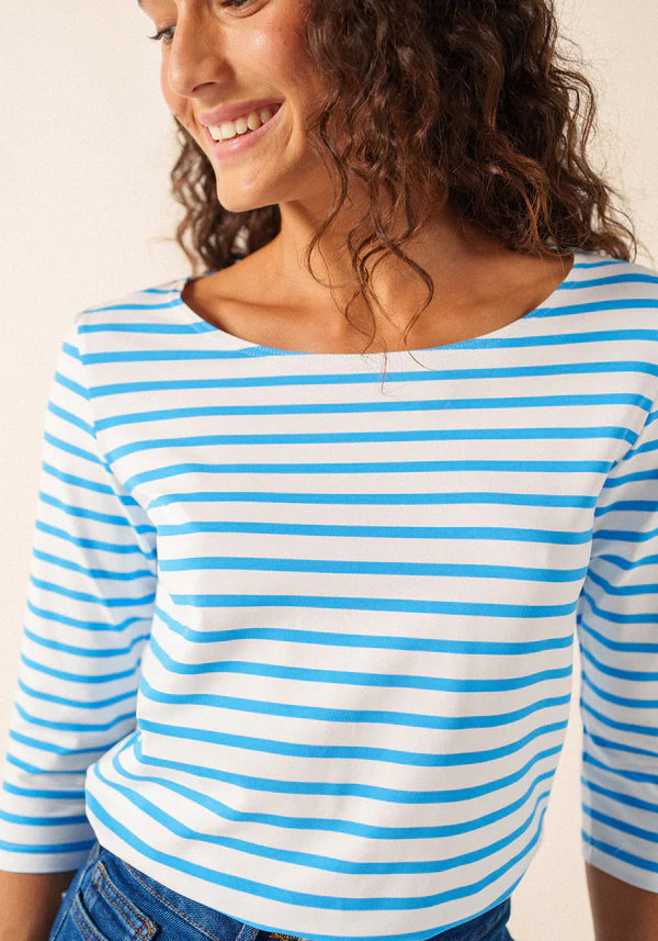 Lächelnde Frau in einer SAINT JAMES Garde-Cote Marinière mit UV-Schutz und blauen Jeans.