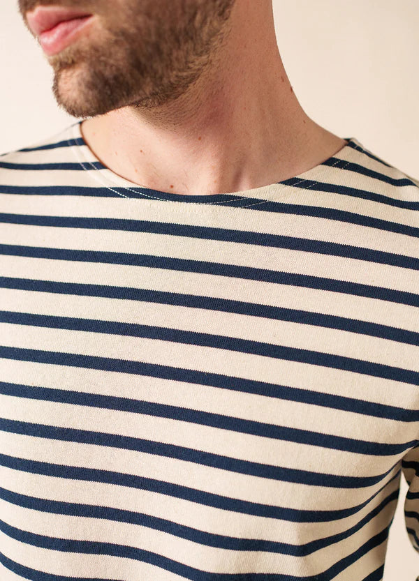 Mann in einem SAINT JAMES Meridien Moderne cremefarben und marineblau Marinière, von den Schultern aufwärts gezeigt.