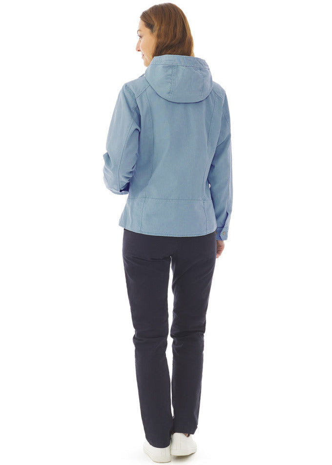 Frau mit Blick nach vorne, trägt die MOUSQUETON Fiona hellblaue Übergangsjacke Damen, schwarze Hose, weiße Schuhe.