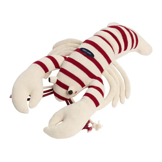 Homard Plüsch von SAINT JAMES mit roten und weißen Streifen, großen Krallen und einem kleinen schwarzen Etikett auf dem Rücken.