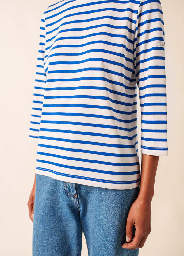 Das Model trägt das SAINT JAMES Galathee marinière femme in blau-weiß gestreift mit Bluejeans, abgebildet von den Schultern bis zur Hüfte.