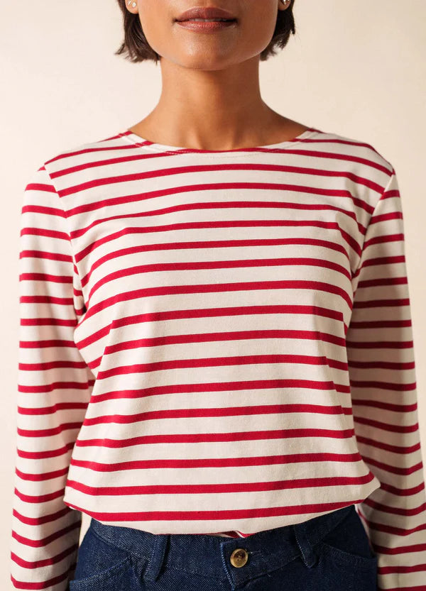 Frau in einem rot-weiß gestreiften, langärmeligen SAINT JAMES Minquidame-Shirt und dunkelblauen Jeans, Schultern bis zur Taille.