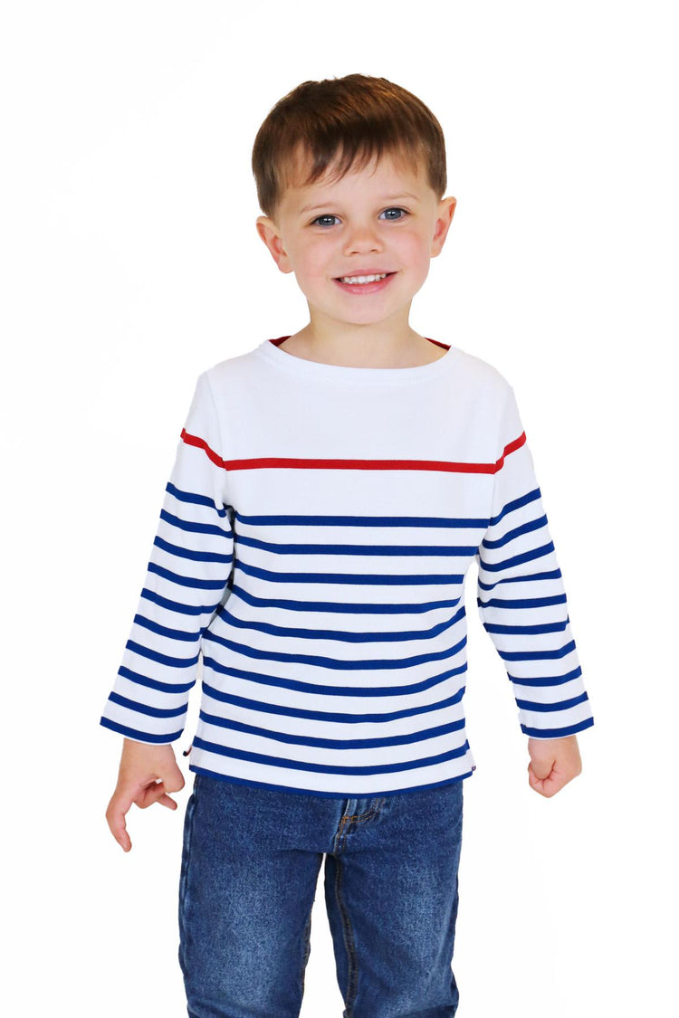 Ein lächelnder Junge in einem MOUSQUETON Mario Kid-Shirt und Jeans steht vor einem schlichten weißen Hintergrund.