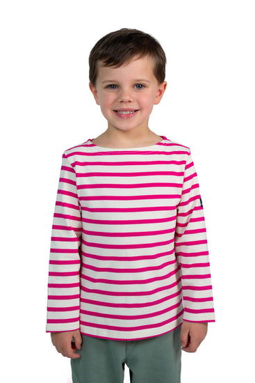 Lächelndes Kind in MOUSQUETONs Mario Kid, rosa gestreiftes Oberteil und grüne Hose, steht vor einem weißen Hintergrund.