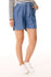 Frau trägt mousqueton Damen-Shorts Amandine aus Lyocell in Denim-Optik, gestreiftes Shirt und weiße Sneaker.