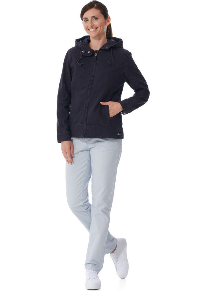 Frau lächelt in einer navyfarbenen Fiona Übergangsjacke Damen von MOUSQUETON, heller Hose und weißen Sneakers.