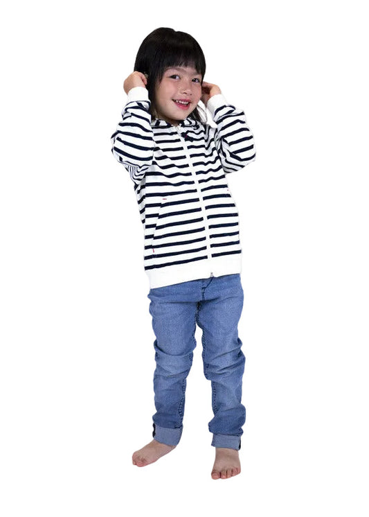 Barfüßiges Kind in einem MOUSQUETON Mulane Kid-Kapuzenpullover hält spielerisch die Kapuze vor einem weißen Hintergrund hoch.