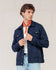Ein Mann, der eine marineblaue Strickjacke von ROYAL MER Lois, ein weißes Hemd und ein orangefarbenes Bandana trägt sowie hellblaue Jeans, blickt nach links.