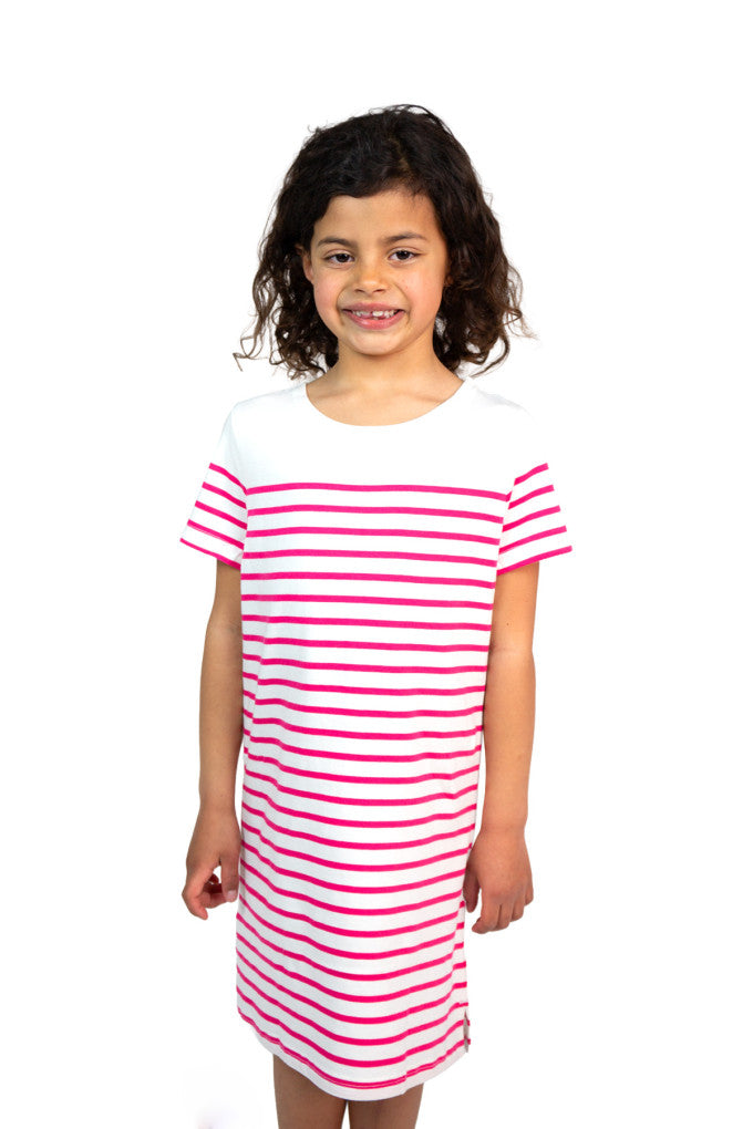 Lächelndes Kind in einem rosa gestreiften, kurzärmeligen Kleid aus Bio-Baumwolle von Mousqueton Tymarianig vor einem weißen Hintergrund.